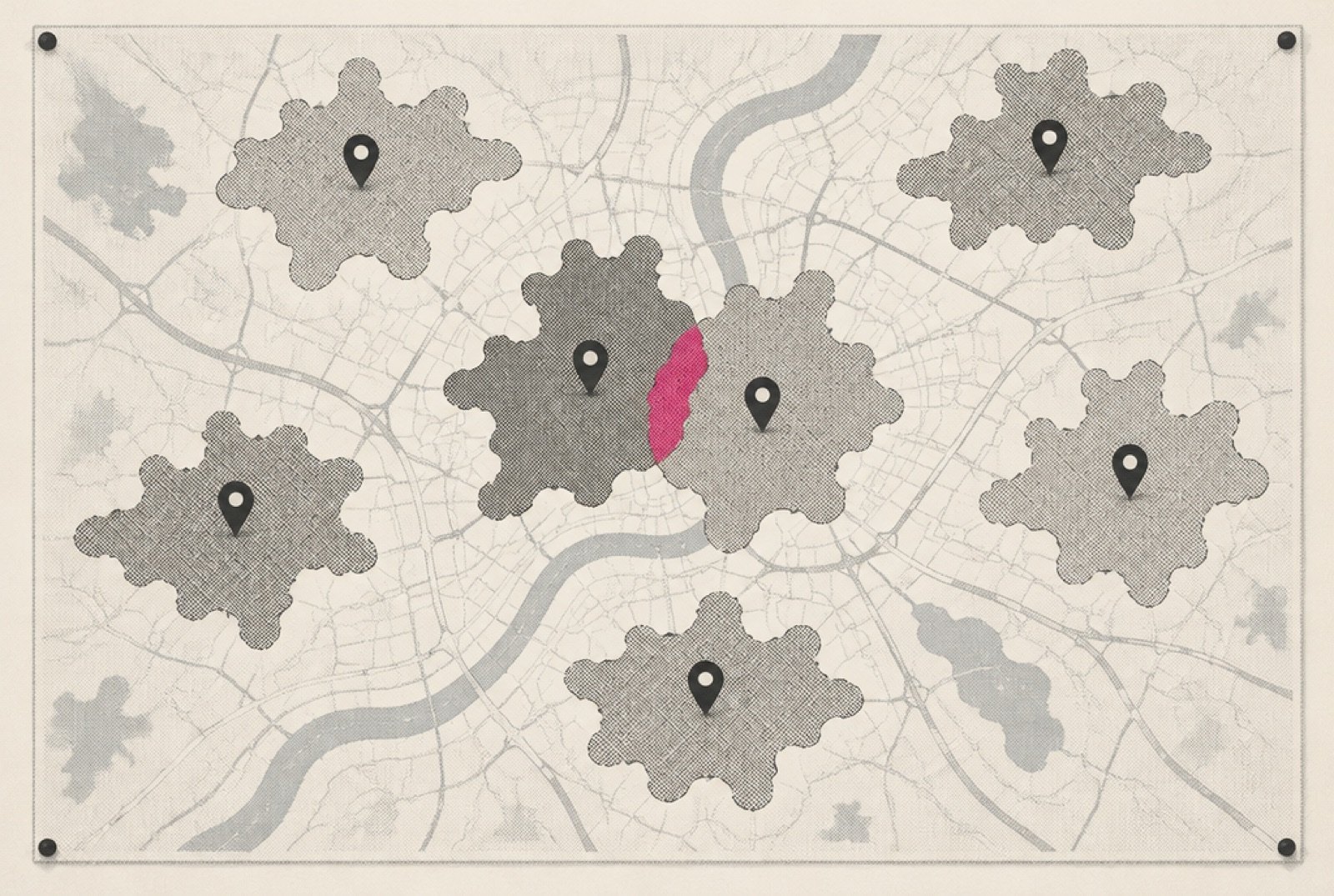 A wall map covered in pins, each surrounded by an irregular drive-time shape, with two neighboring shapes overlapping and the overlap shaded in magenta